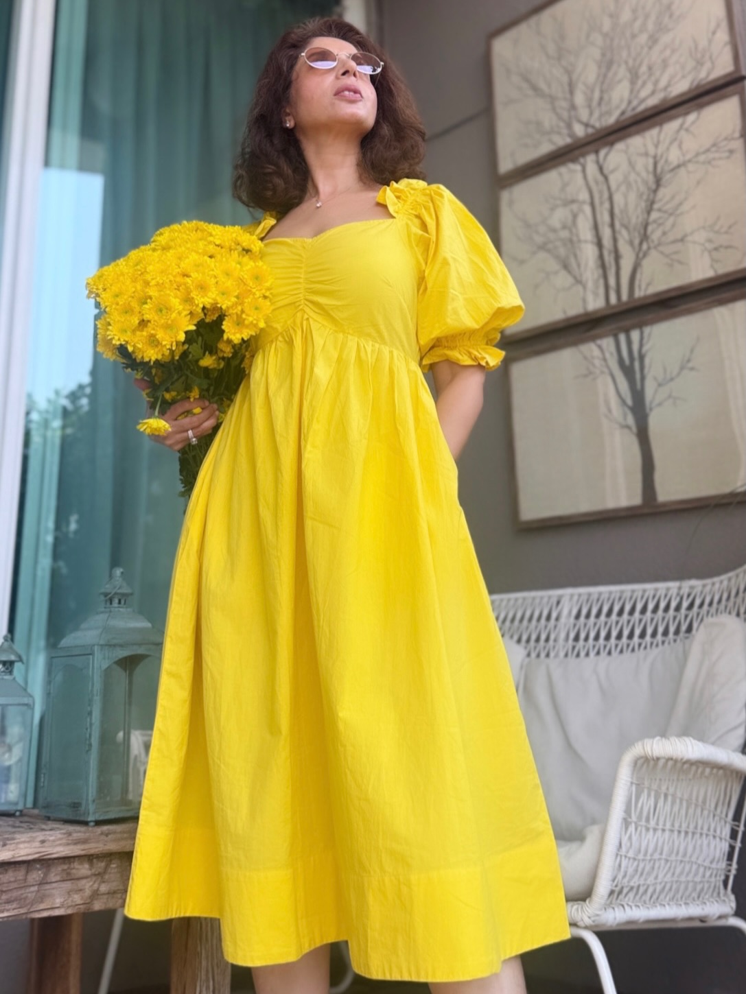 Aiana in a yellow outfit with sunglasses and a relaxed pose